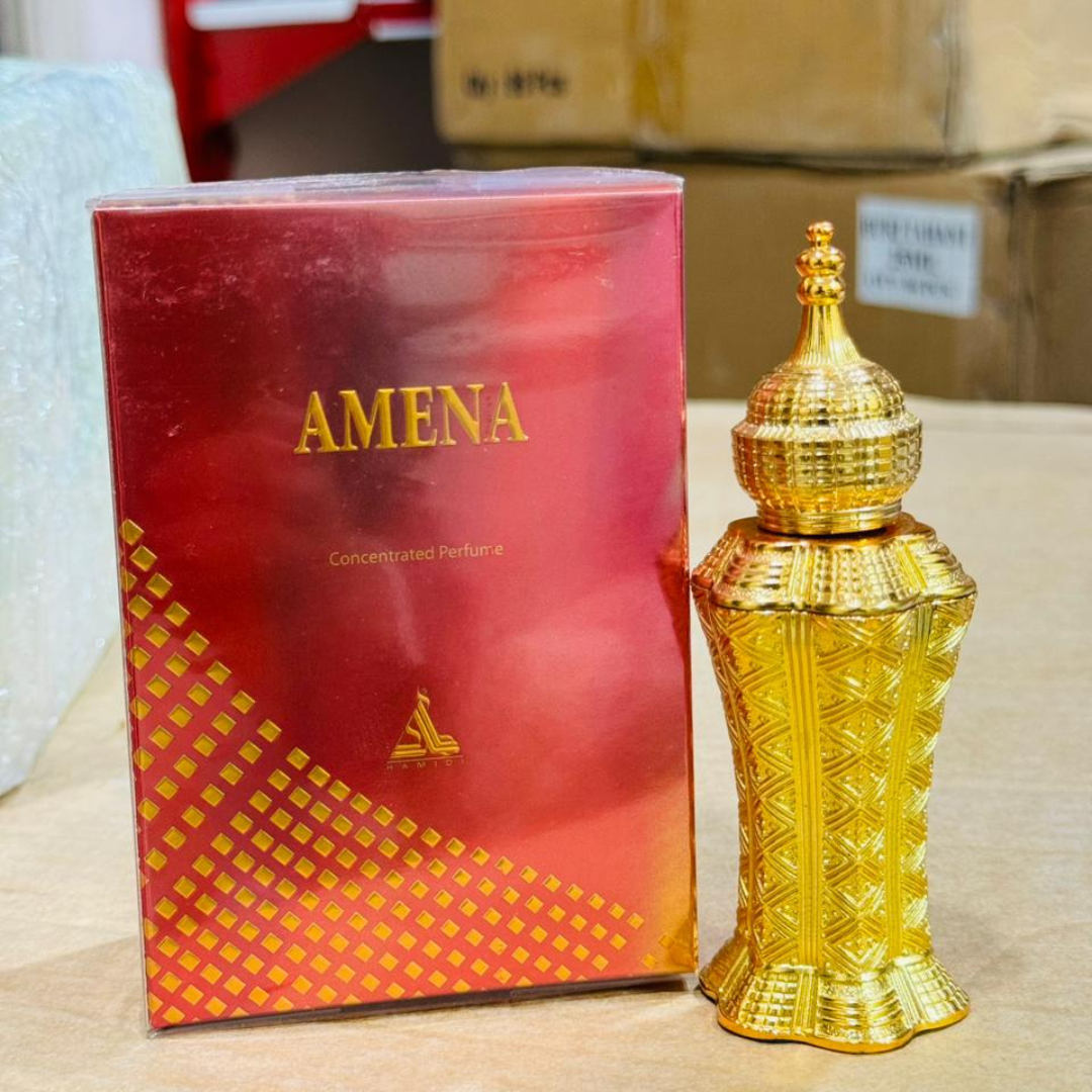 Gold perfume bottle and red packaging with 'AMENA' branding on a wooden surface.