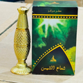 Gold perfume bottle and green box with Arabic text on a light background