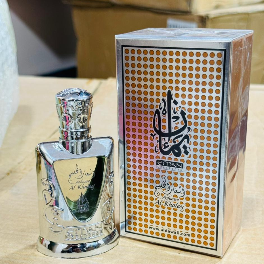 Silver perfume bottle and packaging with intricate design on a wooden surface