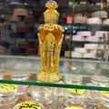 Gold ornate perfume bottle on a shelf with blurred background