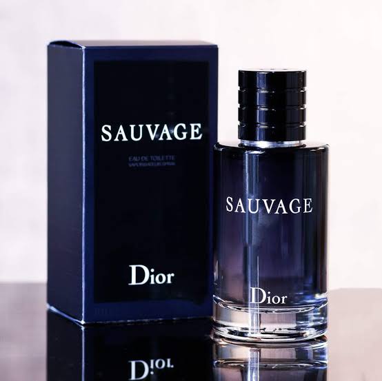 Dior Sauvage perfume bottle and packaging on a reflective surface with a light background